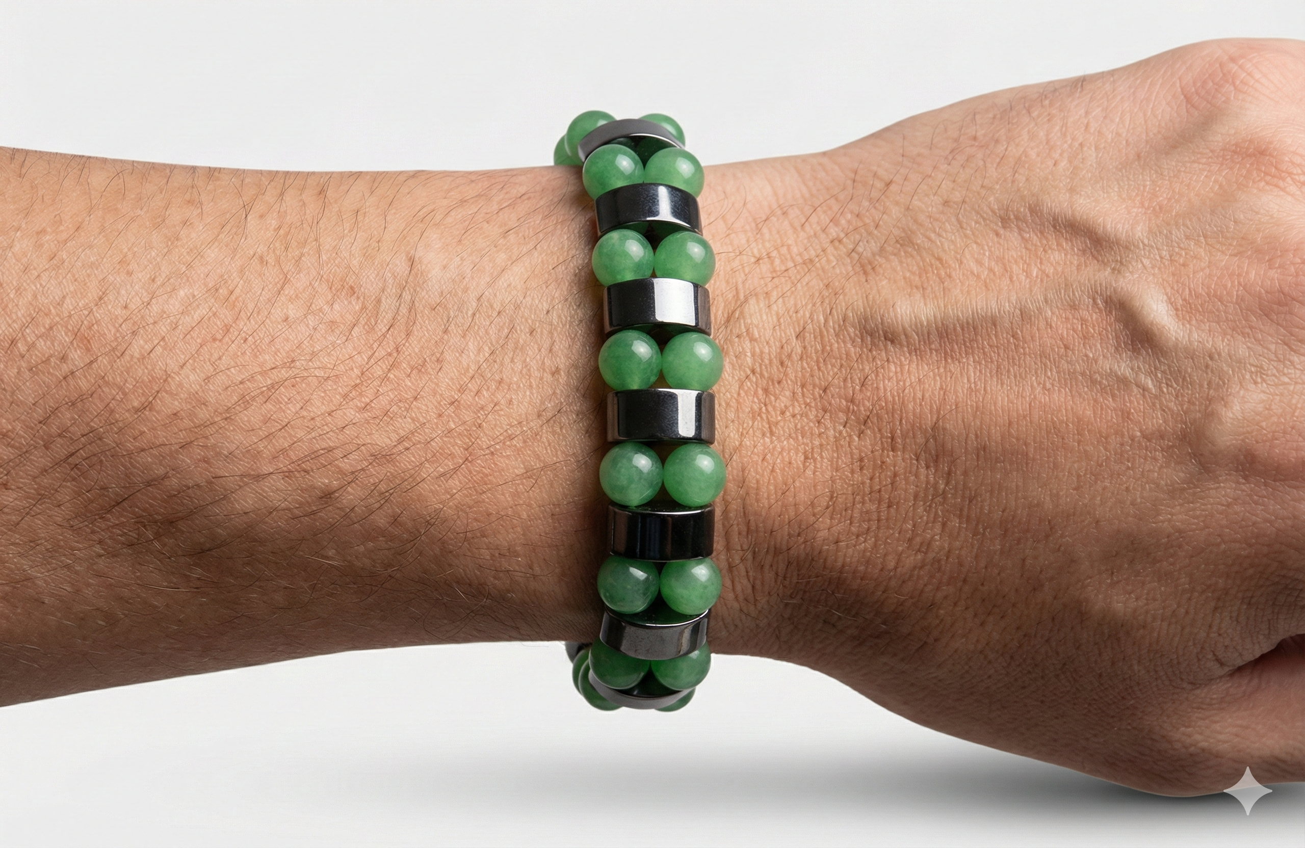 Green beaded bracelet on a wrist against a white background